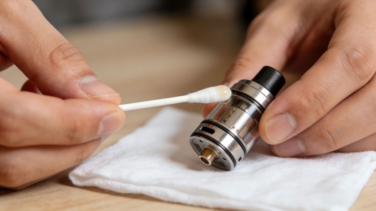 Person carefully cleaning a vape device component