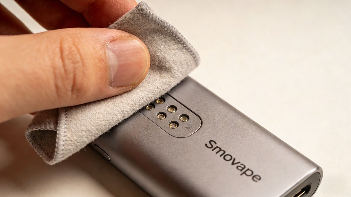 A person cleaning the contact points of their Smovape device with a soft cloth.